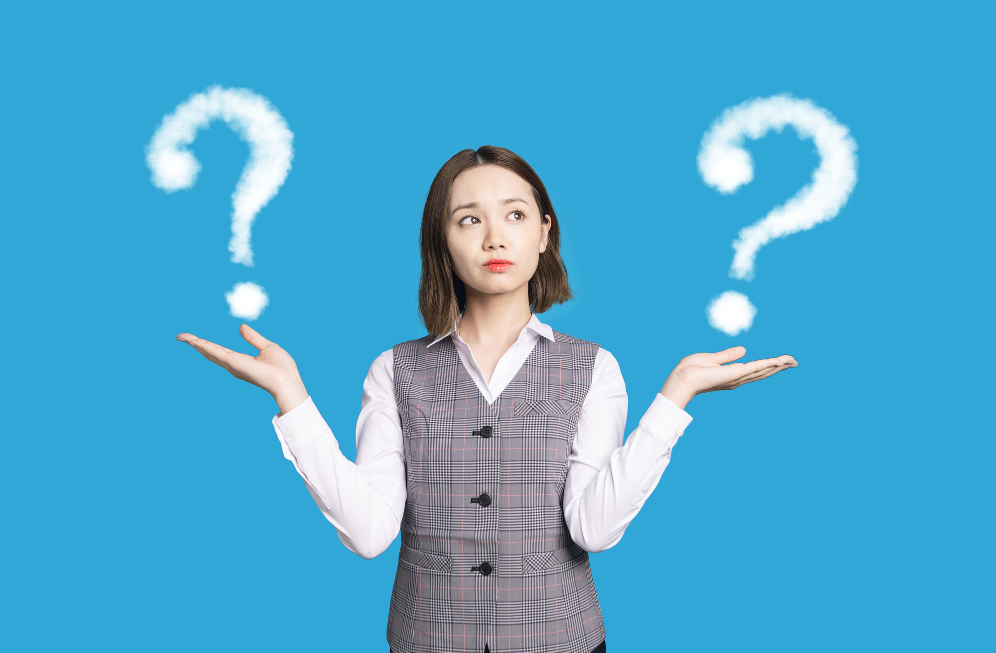 両手をあげて比較について考える女性