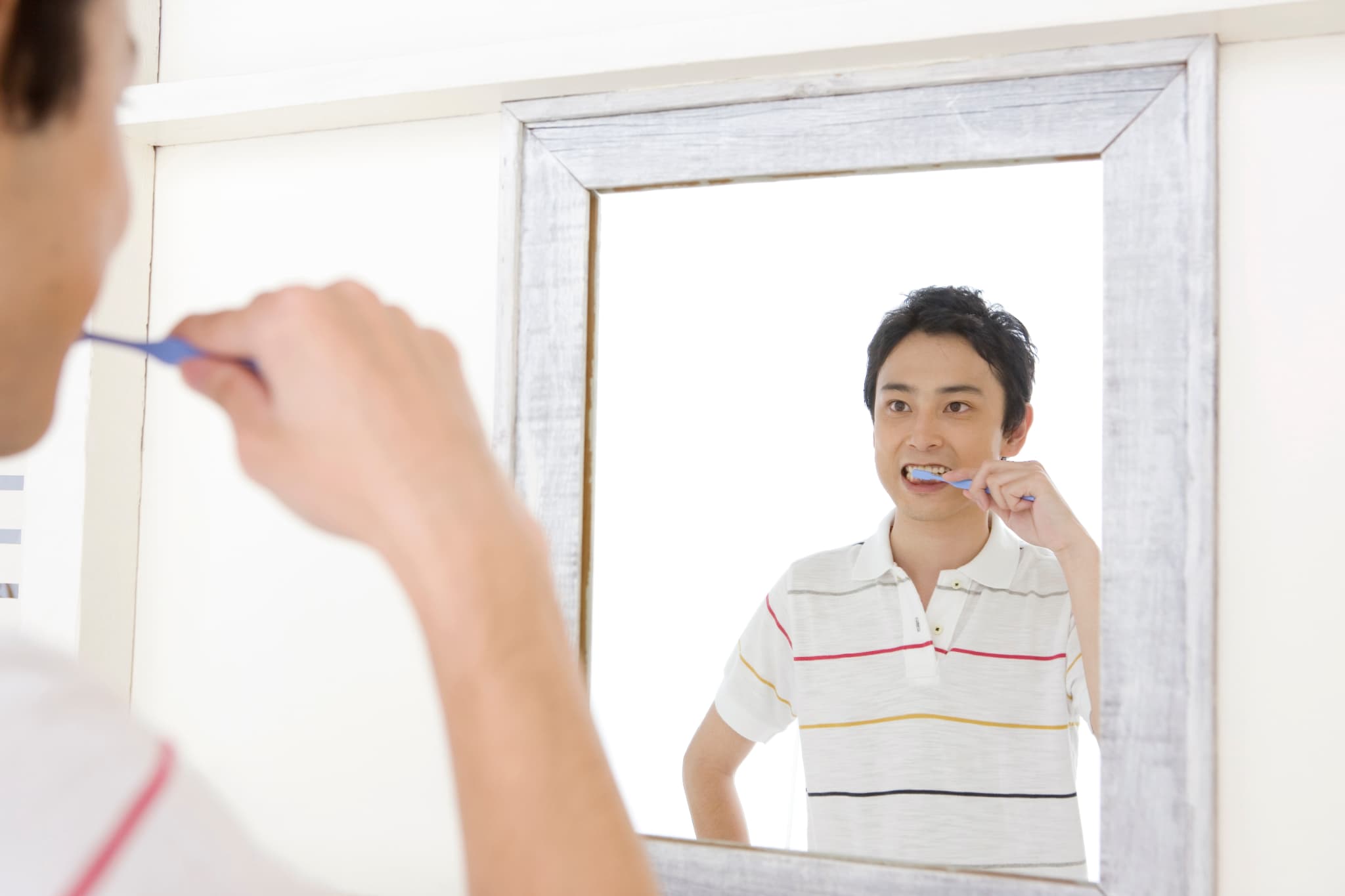 歯磨きをして歯周病を予防する男性