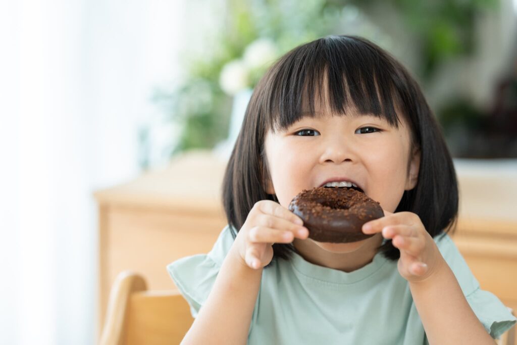 虫歯になりやすいおやつを食べる子ども