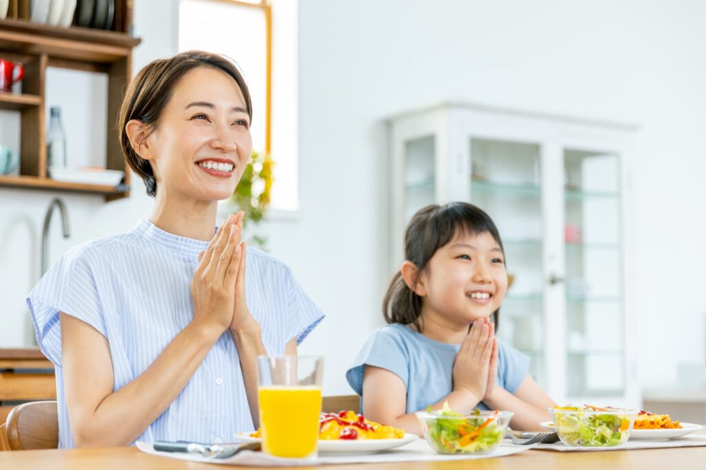 歯のクリーニングをし笑顔で食事をする親子