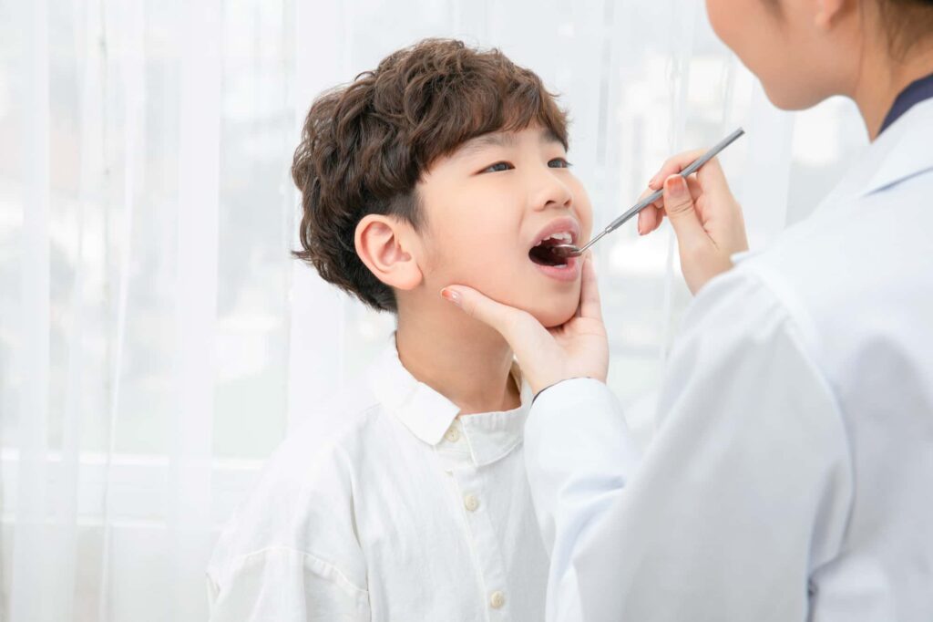 子どもの虫歯を予防するために歯医者で定期検診を受ける男の子