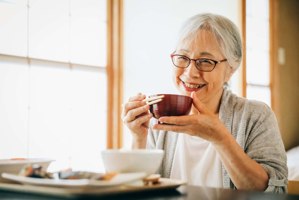 入れ歯のメンテナンスをして快適に食事をする女性