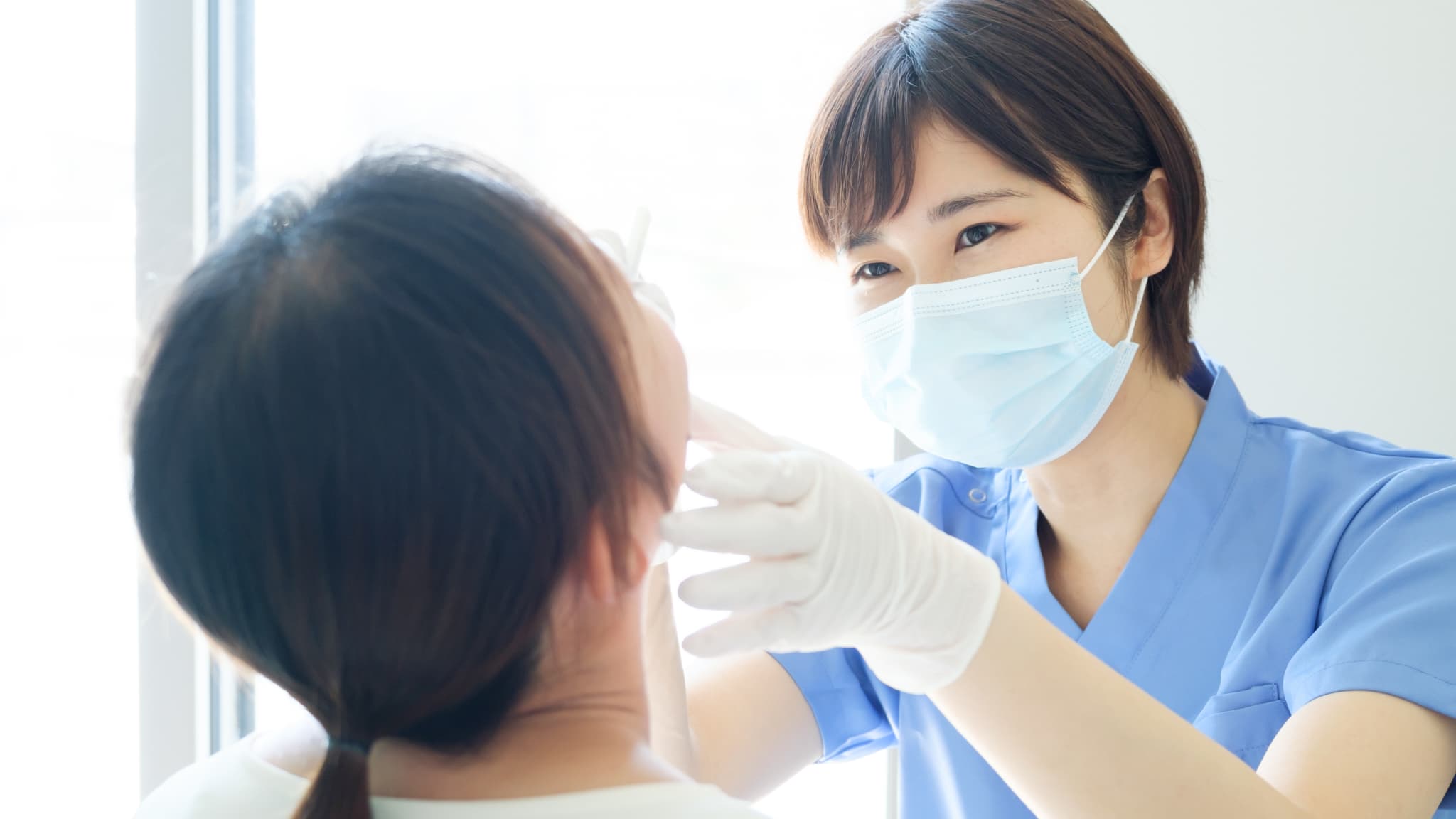 歯医者の定期検診で口腔内のチェックをする歯科衛生士