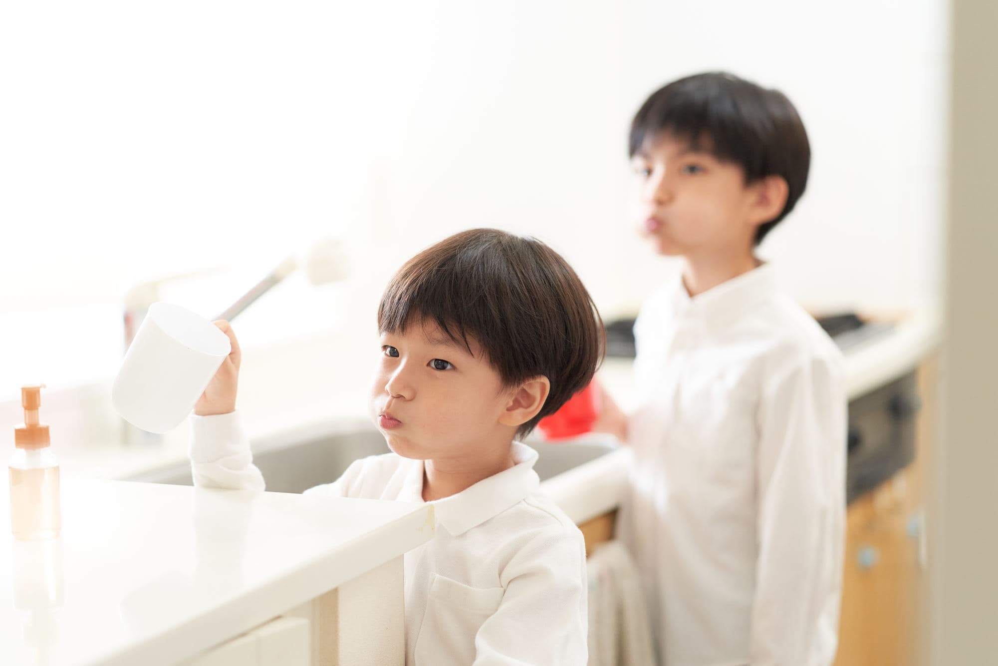 フッ素入りの洗口液でうがいする兄妹