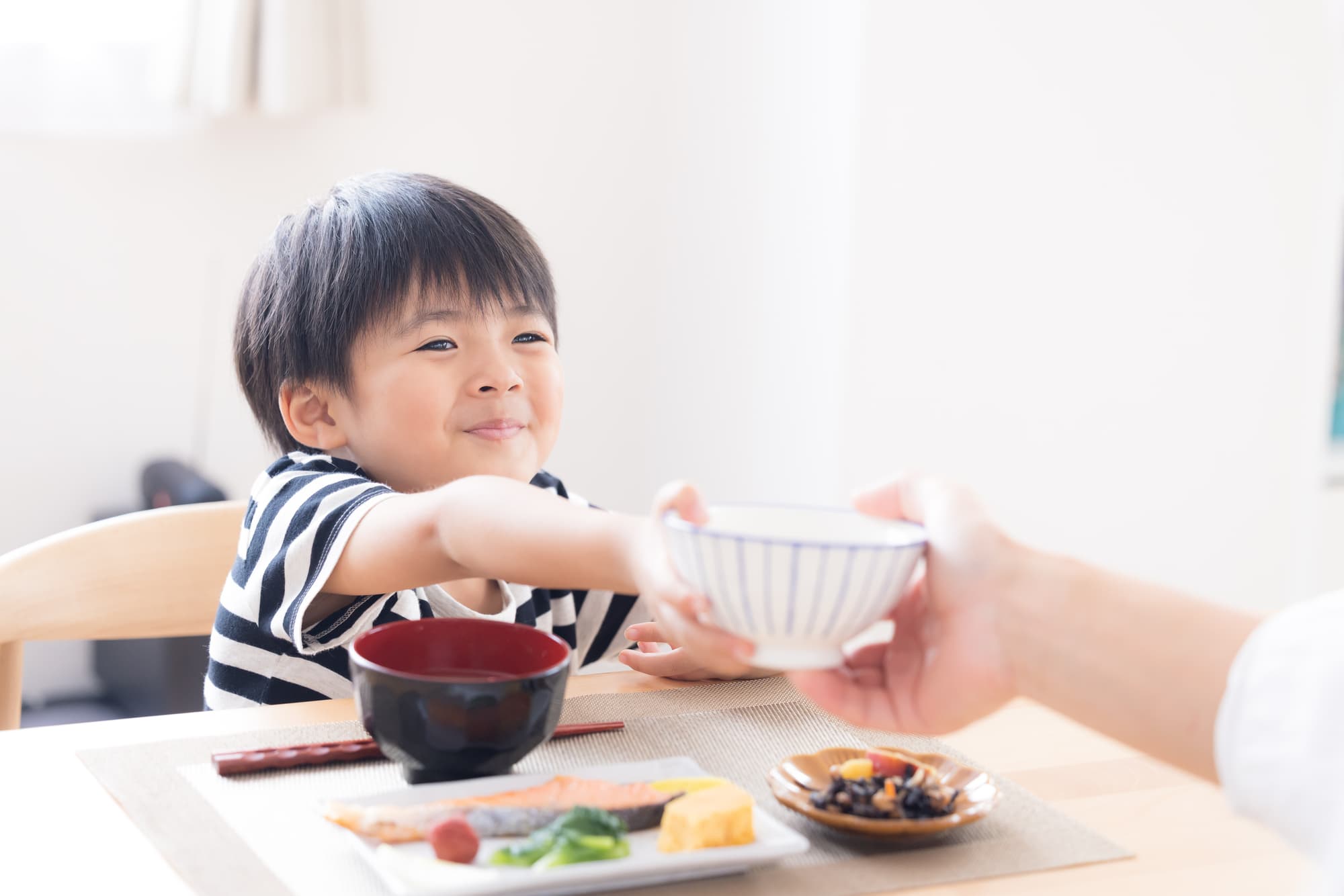美味しそうにごはんをおかわりする子男の子