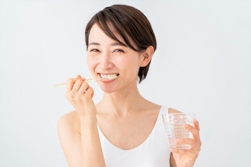 痛みを繰り返さないための予防として丁寧に歯磨きをする女性