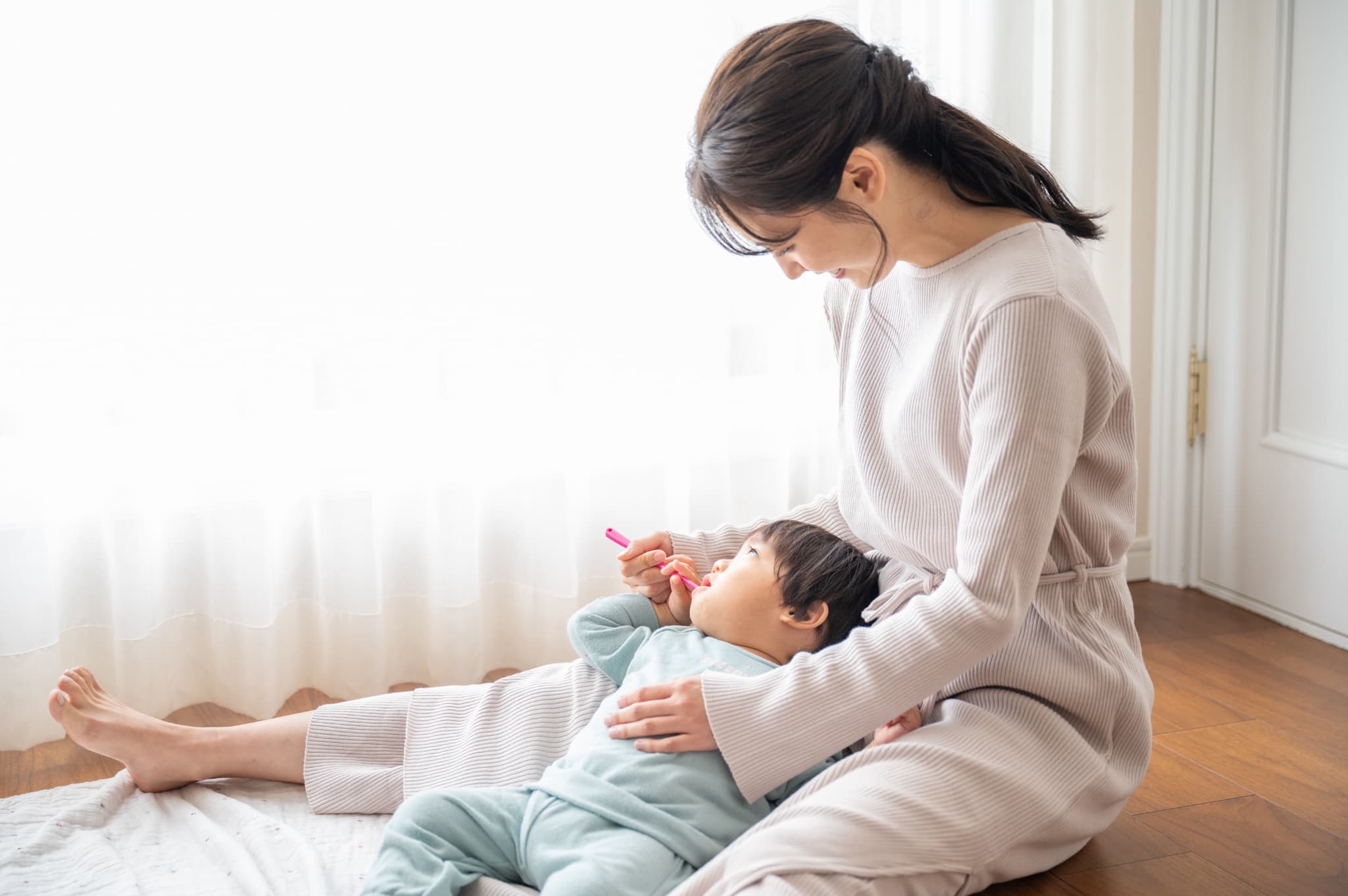 子どもの仕上げ磨きをする母親