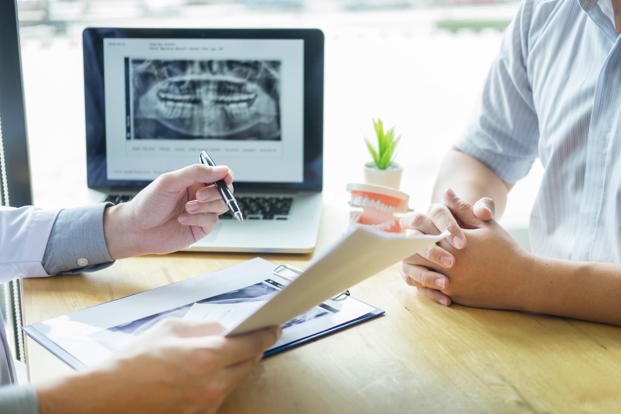 インプラント治療の流れを説明する歯科医師