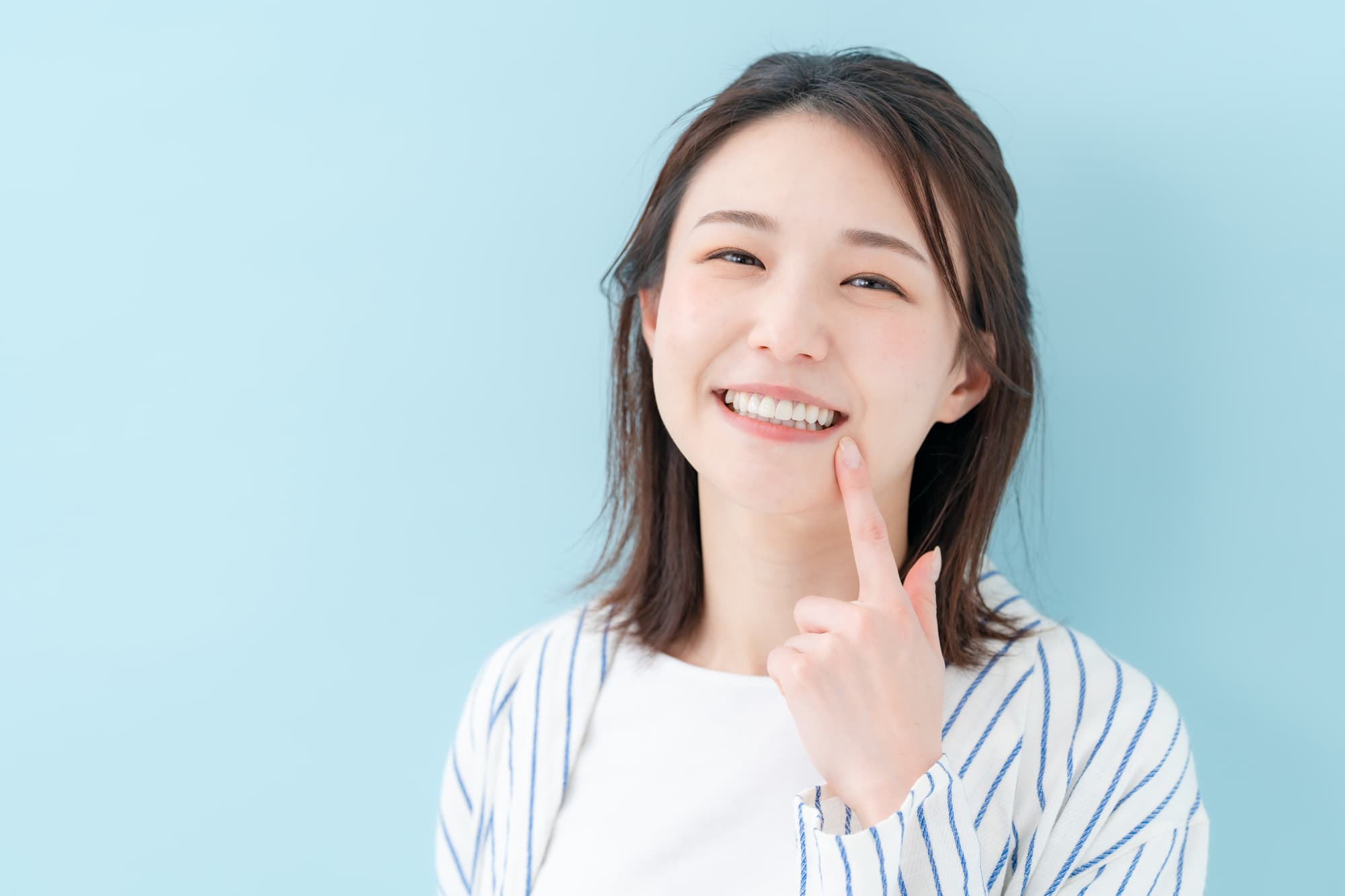 きれいな歯を指さす女性