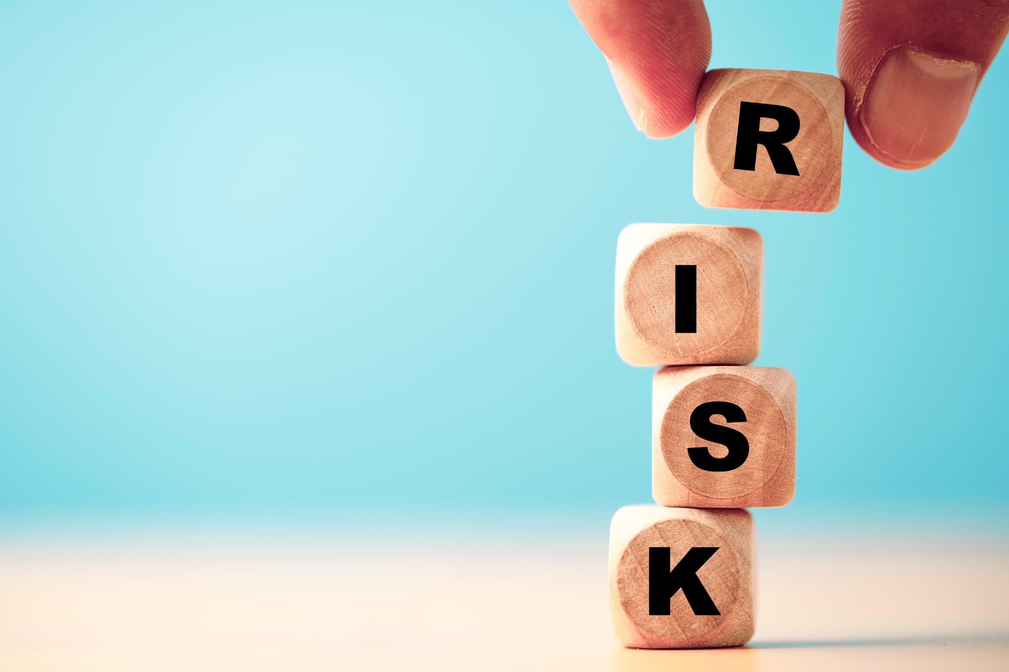 RISKと書かれた木製のブロックを積み上げる指