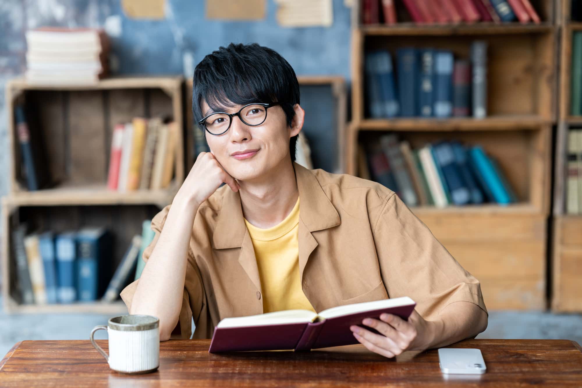 顎関節症の原因になる頬杖をして読書をしている男性