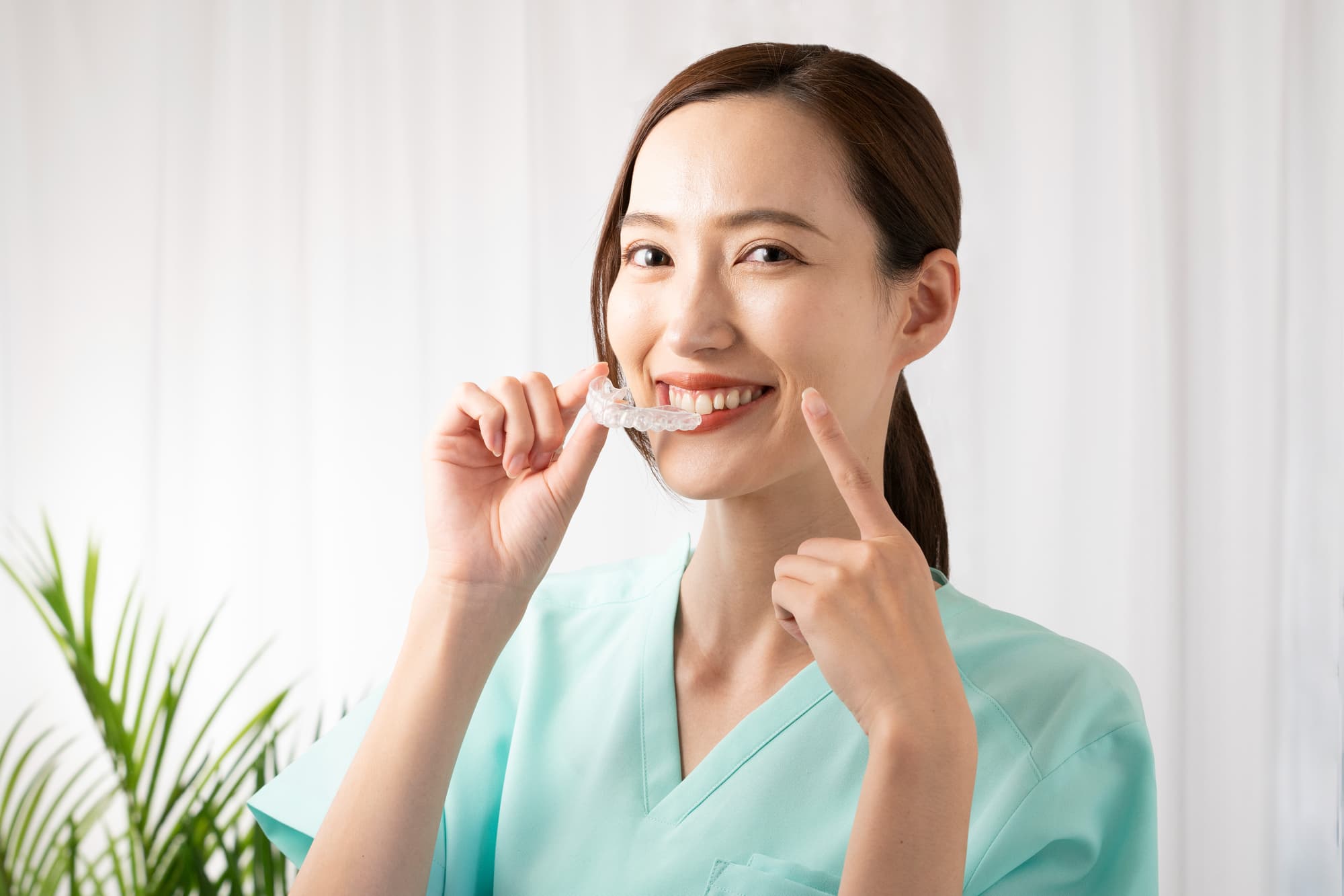 顎関節症を治療するためにスプリント療法をする女性がマウスピースを付けるイメージ