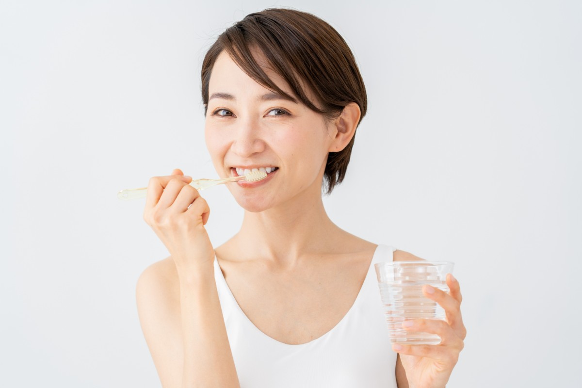 虫歯によって歯が黒くなるのを防ぐために丁寧に歯磨きする女性