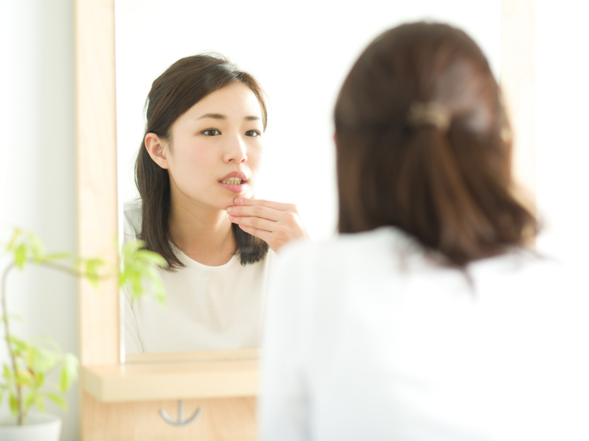 歯周病のセルフチェックとして歯茎を確認している人